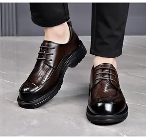 Detail view of men's breathable dark brown perforated business leather shoes worn on floor