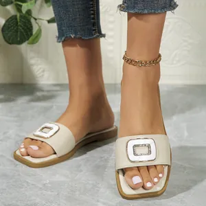 Elegant women's beige flat sandals featuring square toe and sparkling crystal buckle