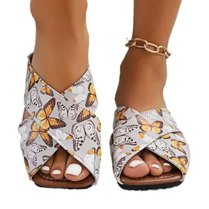 Pantoufles plates imprimé papillon tendance avec brides croisées, idéales pour la plage.