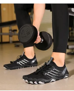 Detailed view of black barefoot water shoes with quick-lace system in a gym setting.