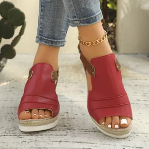 Stylish red peep-toe wedge sandals with espadrille platform sole shown on model feet