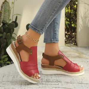 Side view of red women's wedge sandals with espadrille platform sole and brown strap detail