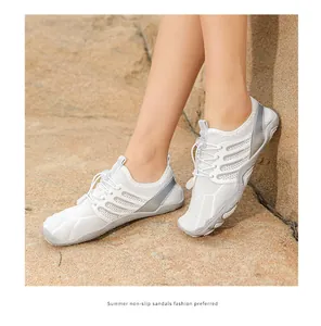 Detail shot of breathable white non-slip beach wading shoes worn on rocky outdoor terrain.