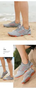 Action shots of unisex grey water shoes with orange accents worn on a sandy beach
