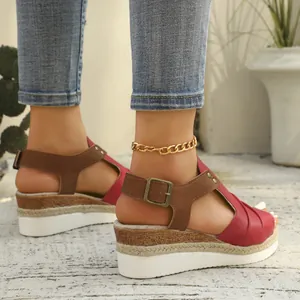 Side detail of women's red wedge sandals with rope-wrapped platform and buckle strap