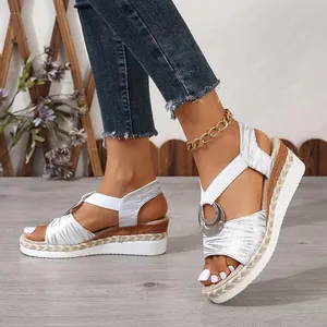 Detailed shot of silver wedge sandals with woven rope platform and metal ring buckle