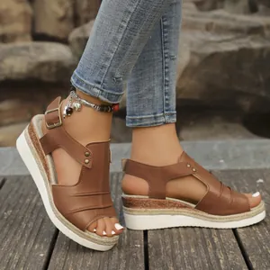 Detailed close-up of stylish brown wedge sandals with rope platform and rivet strap accents.