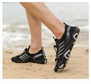 Side view detail of lightweight non-slip water shoes worn on a sandy beach shore