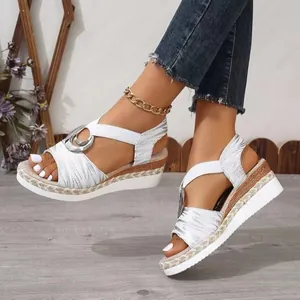 Elegant women's white wedge sandals featuring a metallic buckle and espadrille rope platform.