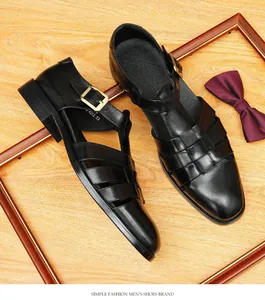 Nahaufnahme von schwarzen Leder-Herrensandalen mit goldener Schnalle auf Holzgrund