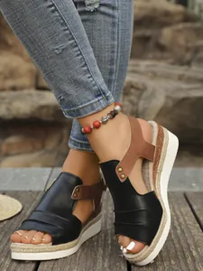 Close-up of women's wedge sandals with rope sole and black faux leather upper