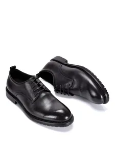 Draufsicht auf schwarze Herrenschuhe aus Leder im englischen Stil auf weißem Grund