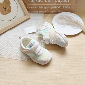 Detail view of pastel gradient kids' breathable mesh sneakers on a wooden table.