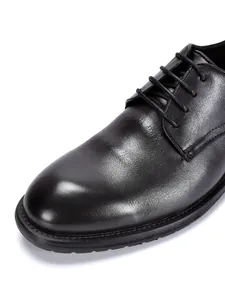 Nahaufnahme der schwarzen Echtleder-Textur bei Herren-Business-Schuhen