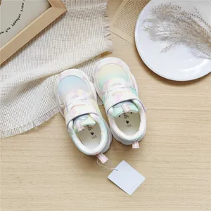 Top view of colorful pastel gradient mesh sneakers for children on wooden background