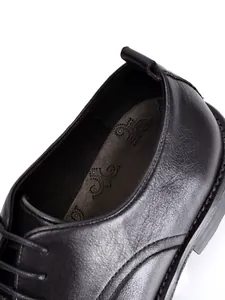 Nahaufnahme schwarzer Lederschuh mit Details der Innensohle und feinen Nähten