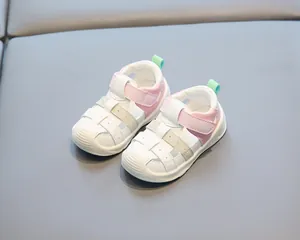 Gros plan de sandales pour tout-petits roses et blanches stylées à fermeture velcro