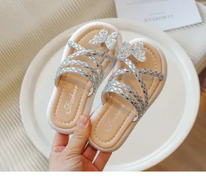 Primer plano de sandalias de princesa para niña con mariposa de diamantes de imitación