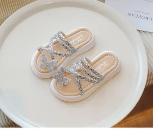 Vista detallada de sandalias para niñas con mariposa de strass brillante y tiras plateadas