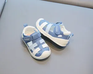 Sandales fermées bleues et blanches pour bébés avec semelle souple antidérapante.