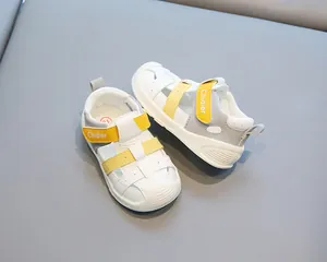 Vue détaillée de sandales pour tout-petits en cuir blanc avec brides jaunes et semelle souple