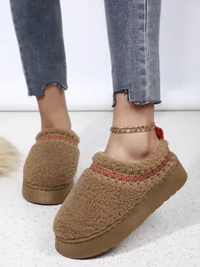 Gros plan de bottes de neige en sherpa marron à plateforme avec broderie détaillée