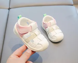 Détail des sandales pour tout-petits en cuir rose et blanc avec bout fermé et semelle souple