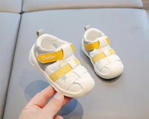 Détail des sandales blanches et jaunes pour bébé avec sangle velcro et logo Chidier