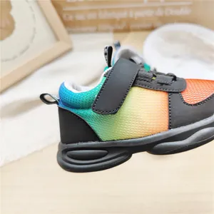 Detailed side view of colorful rainbow gradient mesh kids sneakers with secure Velcro strap