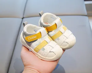 Gros plan de sandales pour bébés avec bride velcro jaune et semelle souple antidérapante.