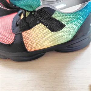 Close-up detail of children's breathable sneakers with rainbow gradient mesh design.