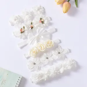 Detailansicht eleganter weißer Babystirnbänder mit Spitzenblumen und weichen Perlen