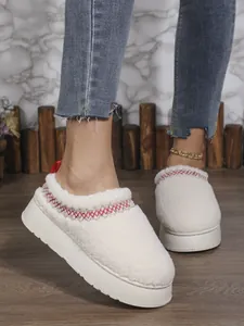 Vue détaillée de chaussures plateforme en sherpa blanc chaud avec broderie rouge