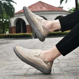Close-up of men's breathable khaki mesh slip-on loafers shown on feet outdoors