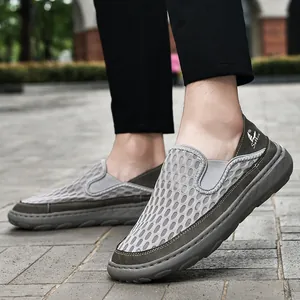 Detailed macro shot of breathable grey mesh summer loafers for men on pavement.