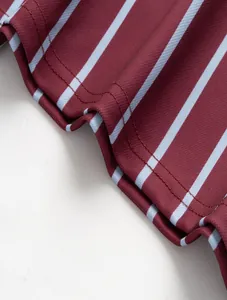 Detailed macro view of men's striped polo shirt featuring double-needle hem stitching