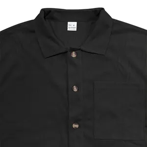 Primo piano dettagliato di camicia nera a coste verticali con colletto a rever e bottoni marmo.