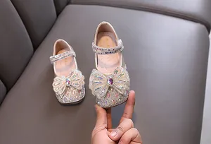 Vista detallada de zapatos de princesa para niña con una gran decoración de lazo de pedrería fina