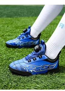 Detailed macro view of blue children's soccer shoes with flame pattern on turf field