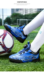 Blue kids' soccer turf shoes with flame graphics and quick dial lacing system.