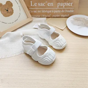 White children's sports sandals with mesh upper and Velcro straps in lifestyle setting