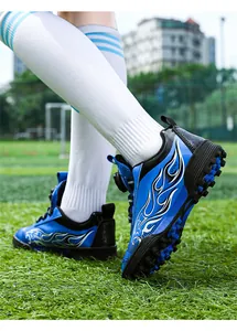 Close-up of blue flame design kids soccer shoes for outdoor turf training