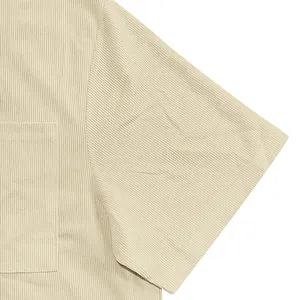 Dettaglio camicia da uomo in velluto a coste beige con trama a righe e taschino