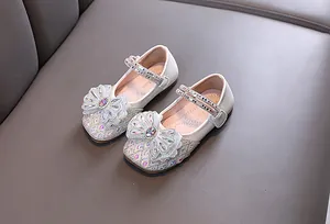 Vista detallada de zapatos de princesa para niña con pedrería brillante y un gran lazo