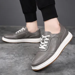 Detailed view of men's grey genuine leather sneakers with lightweight white soles