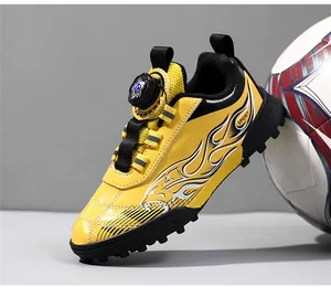 Close-up of yellow kids' football shoe with rotary lacing and tiger stripe flame pattern
