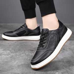 Detail view of black pebbled leather men's sneakers with white contrast stitching and sole.