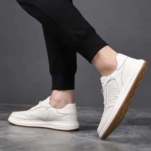 Side view of white leather men's sneakers with micro-perforations and brown gum sole