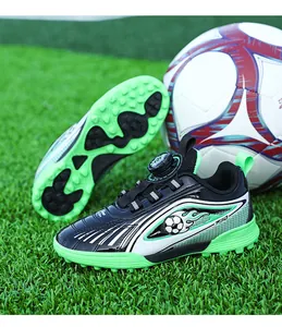 Dettaglio di scarpe da calcio per bambini con suola turf e chiusura girevole su erba.