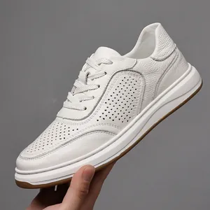 Close-up of a white perforated genuine leather sneaker showing premium texture and side profile